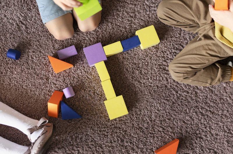 vue-de-dessus-des-enfants-jouant-avec-des-jouets-colores